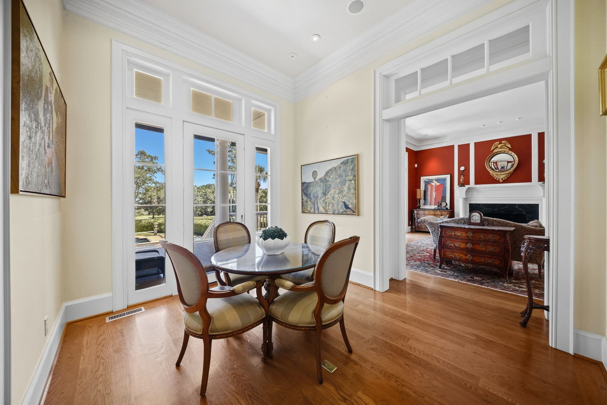 Breakfast nook with French doors to an outdoor porch, and a large framed painting on the near wall.