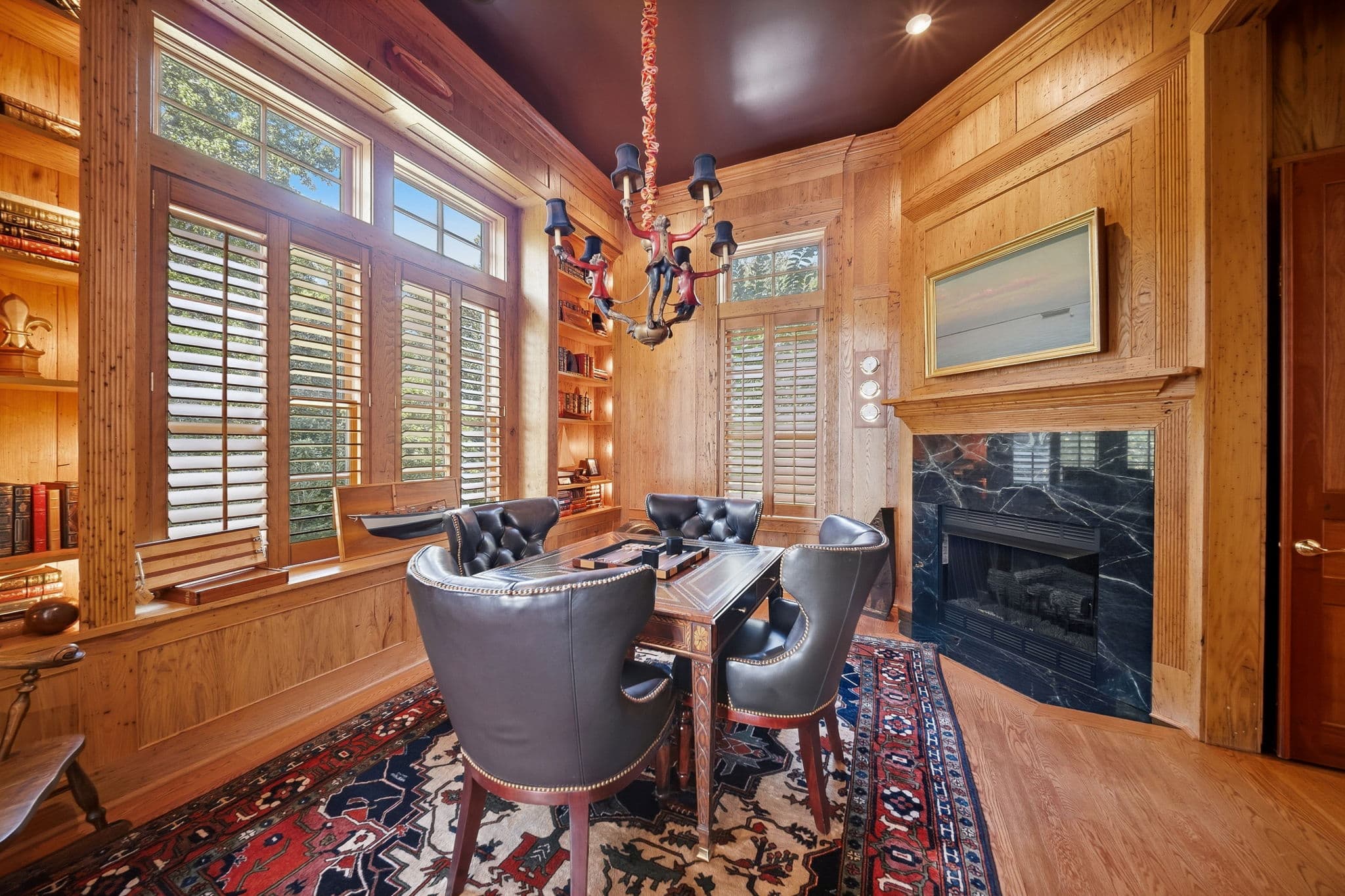 Study with black marble fireplace, a seascape painting above the mantel, and a backgammon table in the foreground.