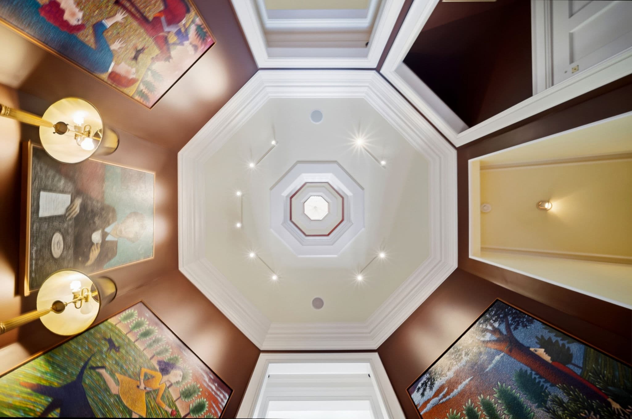 Upward view of an octagonal ceiling cupola with layered molding and a central skylight.